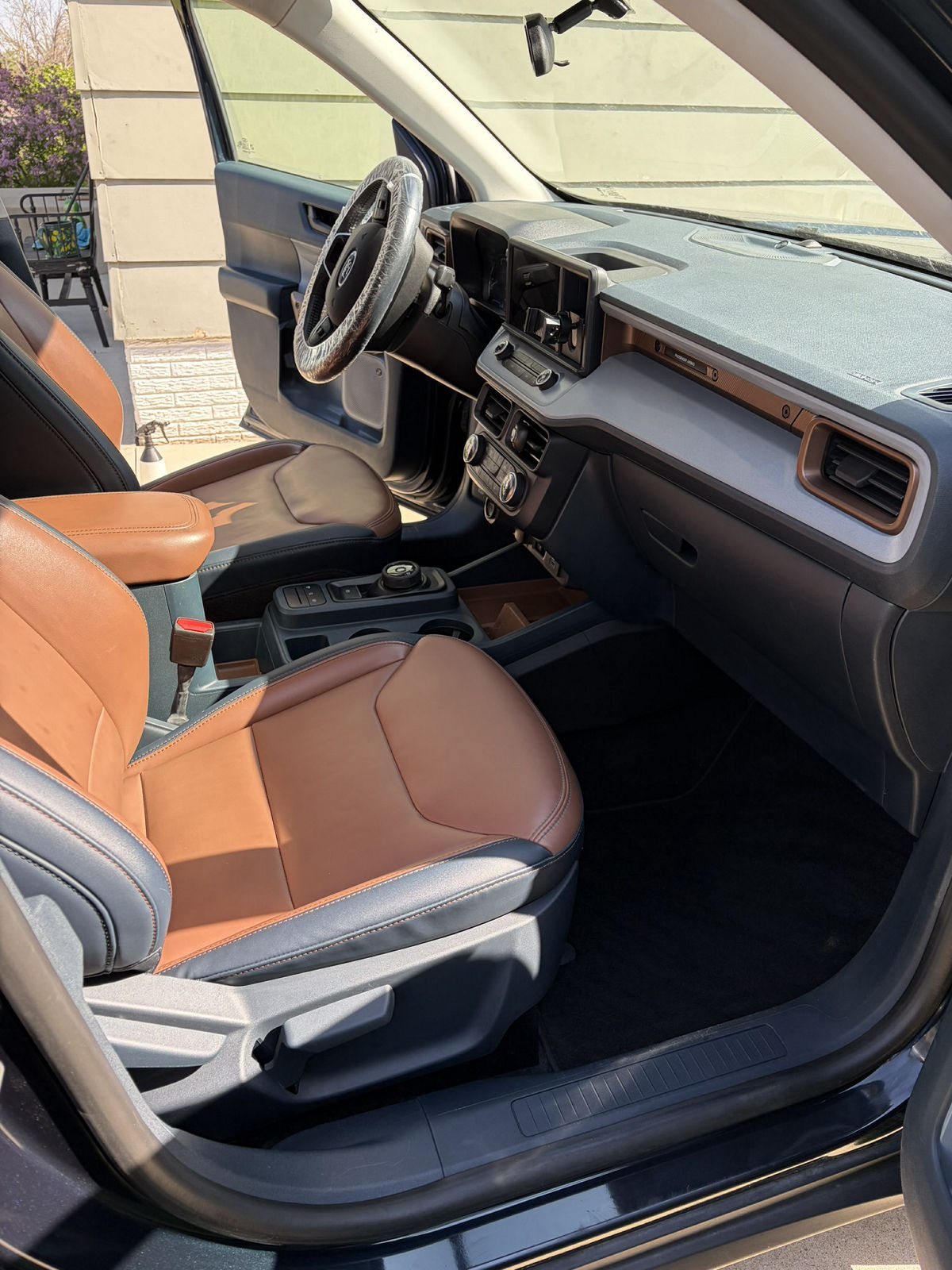 Freshly detailed driver's seat and dashboard with conditioned two-tone leather and clean door panels