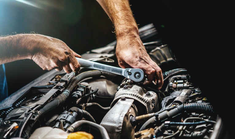 Mobile mechanic performing engine diagnostics and hands-on inspection with scan tool